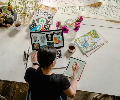 Photo of Woman Writing on Tablet Computer While Using Laptop